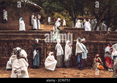 Lalibela, Äthiopien - 04. November 2018: Menschen in weißen Mänteln beten auf der Terrasse einer wunderschönen Felsenkirche in Lalibela, Äthiopien Stockfoto