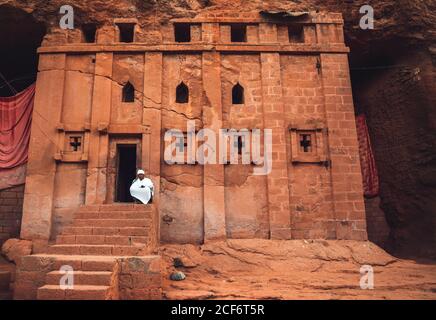 Lalibela, Äthiopien - 04. November 2018: Priester sitzt auf der Veranda der alten Rock-gehauen orthodoxen Kirche in Lalibela, Äthiopien Stockfoto