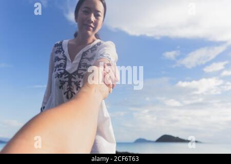 Hände von Frau und Mann, die sich gegenseitig erreichen, unterstützen. Eine helfende Hand geben. Stockfoto