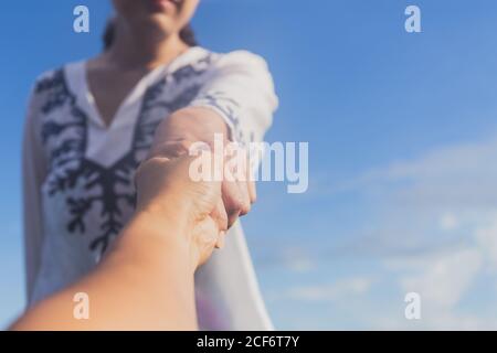 Hände von Frau und Mann, die sich gegenseitig erreichen, unterstützen. Eine helfende Hand geben. Stockfoto