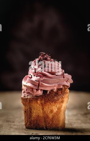 Köstliche hausgemachte Cupcakes auf rustikalem Hintergrund Stockfoto