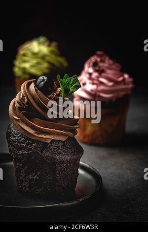 Köstliche hausgemachte Cupcakes auf rustikalem Hintergrund Stockfoto