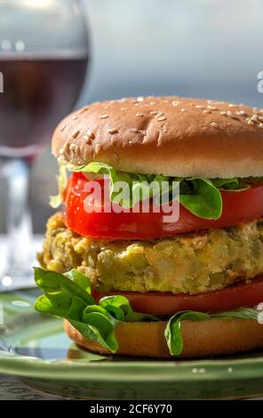 Hausgemachter gesunder veganer grüner Linsenburger mit Tomaten, Salat und pommes Frites Stockfoto