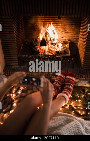 Anonyme Frau sitzt und fotografiert den Kamin Stockfoto