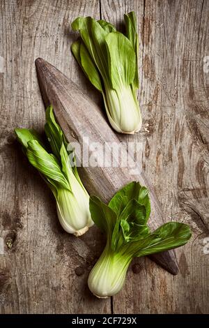 Draufsicht auf reifen Bok Choy in der Nähe von Holzplatte platziert Auf einem schäbigen Holztisch in der Küche Stockfoto