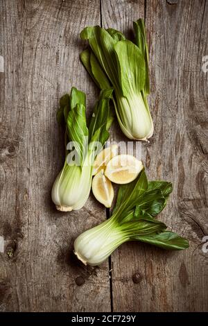 Draufsicht auf reifen Bok Choy in der Nähe von Holzplatte platziert Auf einem schäbigen Holztisch in der Küche Stockfoto