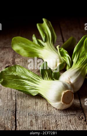 Draufsicht auf reifen Bok Choy in der Nähe von Holzplatte platziert Auf einem schäbigen Holztisch in der Küche Stockfoto