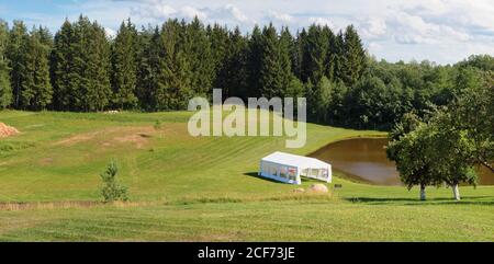 Hochzeitszelt am Ufer eines Dorfes Teich Panorama Querformat Stockfoto