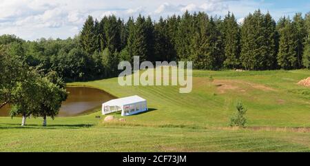 Hochzeitszelt am Ufer eines Dorfes Teich Panorama Querformat Stockfoto