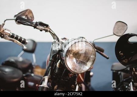 Schäbige Oldtimer Motorräder mit kaputten Scheinwerfern in der Reparaturwerkstatt geparkt Stockfoto