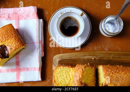 Von oben Blick Tasse heißen Tee in der Nähe geschnitten Biskuit Schokoladenkuchen und Eier in der Küche Stockfoto