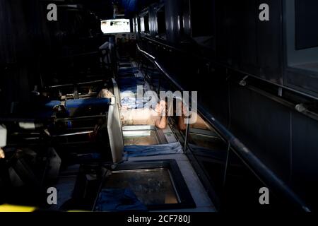 Attraktive Soldatin, die im Dunkeln auf die Kamera schaut hangar Stockfoto
