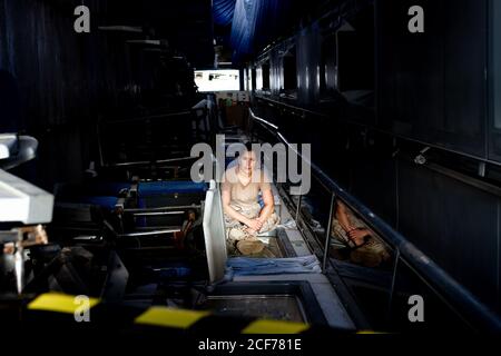 Attraktive Soldatinnen, die in der Dunkelheit sitzen und die Kamera betrachten hangar Stockfoto
