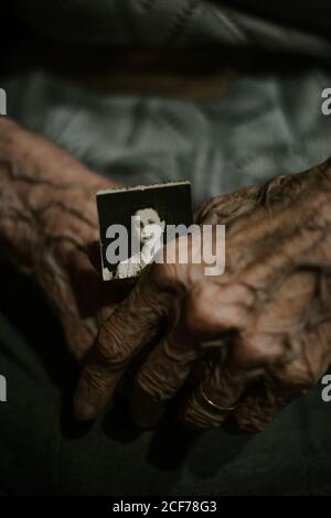 Von oben anonymen älteren Person mit gealterten Foto zu Hause Stockfoto