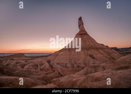 Steiniger Berggipfel in trockenem Gelände gegen Sonnenuntergang Himmel am Abend in Bardenas Reales in Navarra, Spanien Stockfoto