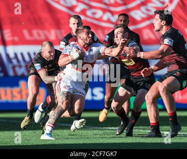 Greg Minikin (5) von Hull KR wird von Liam angegangen Byrne (20) von Wigan Warriors Stockfoto