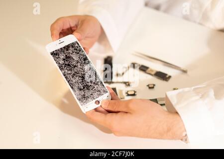 Schneiden Sie die Hände mit defekten Smartphone-Display Stockfoto