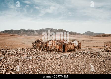 Verfallene alte Gebäude in der Bergwüste unter wolkenverwitterten Himmel Stockfoto