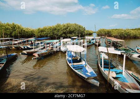 Gambia - 4. August 2019: Malerischer Pier mit Holzbooten auf kristallklarem Wasser an der Küste Stockfoto