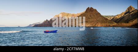 Blaues Segelboot im Meer und schöne Felsen Stockfoto