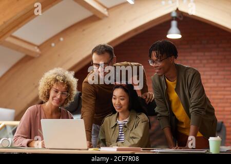 Gruppe von kreativen Geschäftsleuten, die online auf Unternehmenspräsentation zuschauen Laptop zusammen im Büro Stockfoto