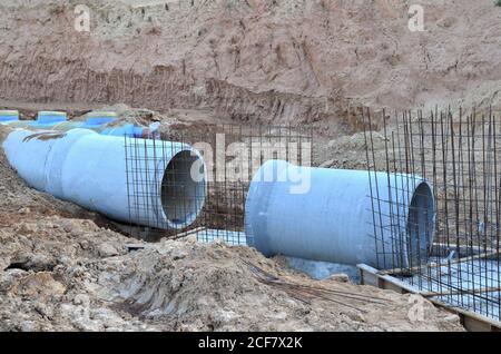 Verlegung von unterirdischen Regenwasserkanalrohren auf der Baustelle. Installation von Wasserleitung, Sanitärinstallation, Sturmflutanlagen. Betonabflussrohr Stockfoto