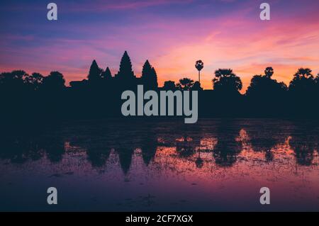 Majestätischer Blick auf lebendige Sonnenuntergang Himmel über Silhouette der orientalischen Tempel und ruhiger See Stockfoto