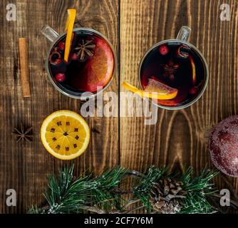 Glühwein mit Orangen und Gewürzen auf dem Holztisch Stockfoto