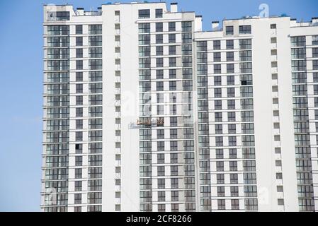 Hängewiege an der Fassade des Wolkenkratzers. Mobile Gerüstplattform für Bauarbeiten in der Höhe, Fassadenreinigung, Verputzen, Fenster war Stockfoto