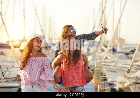 Frau, die Freundin auf dem Rücken trägt und Selfie nimmt Stockfoto
