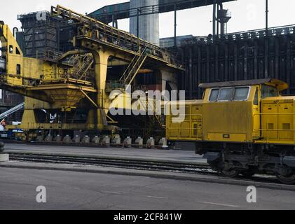 Von unten von der Pusher-Maschine und der elektrischen Lokomotive auf dem Werk Herstellung von Koks aus Kohle in Öfen Stockfoto