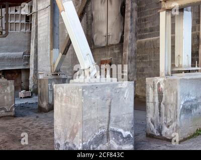 Details von massiven verwitterten Metallkonstruktionen auf Betonboden platziert Das Hotel befindet sich in einer verlassenen Werkstatt eines schäbigen Industriegebäudes Stockfoto