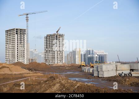 Straßenbau auf der großen Baustelle auf Turmdrehkrane Hintergrund. Installation von Wasserleitung und Sanitärinstallation. Installation von Konz Stockfoto