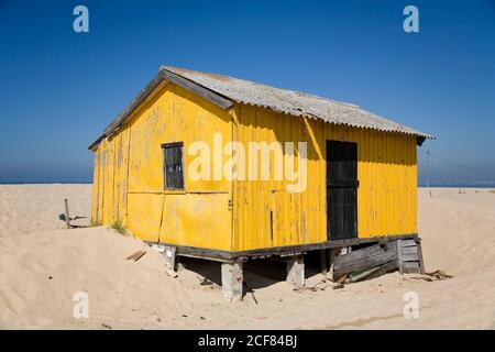 Kleines buntes Haus mit schäbigen Wänden am Sandstrand Mit blauem Himmel im Hintergrund an sonnigen Tagen Stockfoto