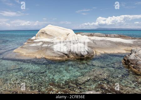 Malerische weiße felsige Formation mit klarem kristallklarem Meerwasser in strahlendem Sonnenschein bedeckt, Chalkidiki, Griechenland Stockfoto