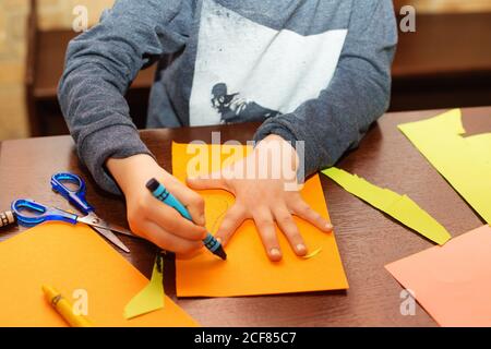 Kind Spuren um eine Hand auf Papier mit Buntstiften. Eine einfache Zeichnung der Hand eines Kindes. Verfolgen Sie die Handfläche des Kindes. Handverfolgung. Kreativität der Kinder. Stockfoto