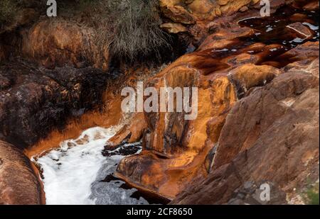 Kleiner roter Flusswasserfall der felsigen Landschaft in Riotinto, Huelva Stockfoto