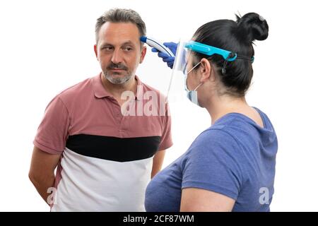 Frauen Modell trägt covid19 sars Influenza-Schutz Ausrüstung Latexhandschuhe Transparenter Gesichtsschutz und medizinische oder chirurgische Maske Messung Temperatur Stockfoto