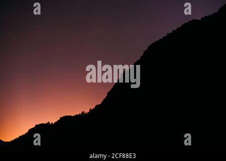 Rosa und lila Himmel über Bergkette bei Sonnenuntergang Stockfoto