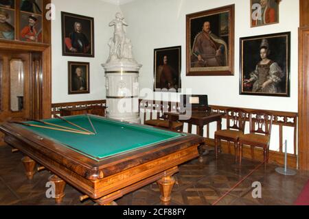 Spielzimmer mit Billardtisch im ehemaligen Jagdschloss des Grafen Gyula Andrássy. Weißer Porzellanofen in der Ecke. Stockfoto