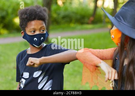 Afrikanischer Junge in Kostüm spielt mit seinem Freund in der parken Sie im Freien Stockfoto