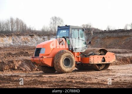 Vibration Einzylinder-Straßenwalze Nivellierung des Bodens für das Fundament. Bodenverdichter für die Asphaltverlegung auf der Straße auf der Baustelle. Straßenverkehrscom Stockfoto