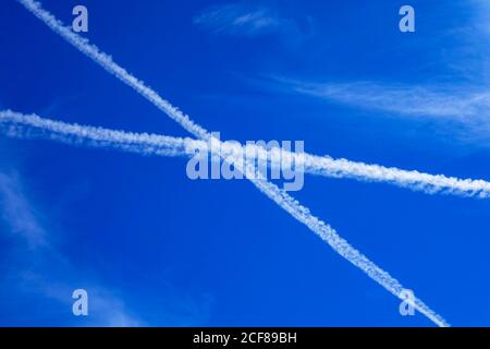 Dampfwege, Contrails in Form eines Kreuzes, in blauem Himmel über den französischen Alpen, Stockfoto