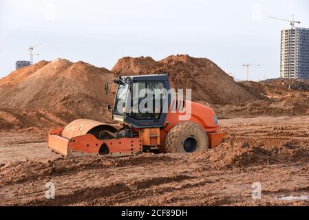 Vibration Einzylinder-Straßenwalze Nivellierung des Bodens für das Fundament. Bodenverdichter für die Asphaltverlegung auf der Straße auf der Baustelle. Straßenverkehrscom Stockfoto