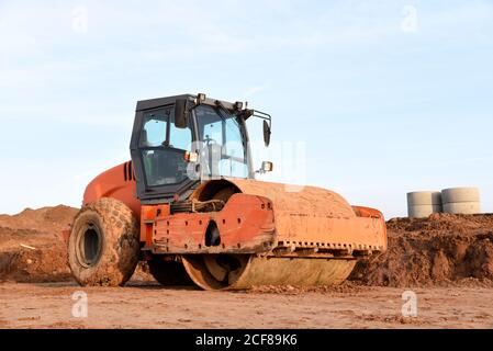 Vibration Einzylinder-Straßenwalze Nivellierung des Bodens für das Fundament. Bodenverdichter für die Asphaltverlegung auf der Straße auf der Baustelle. Straßenverkehrscom Stockfoto