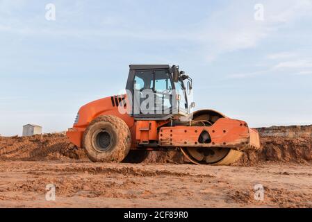 Vibration Einzylinder-Straßenwalze Nivellierung des Bodens für das Fundament. Bodenverdichter für die Asphaltverlegung auf der Straße auf der Baustelle. Straßenverkehrscom Stockfoto