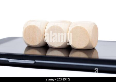 Drei leere Holzwürfel auf einem Smartphone-Bildschirm. Leere Würfel mit Symbolraum auf dem Handy-Display. 3 Elemente, Technologiewürfel Stockfoto