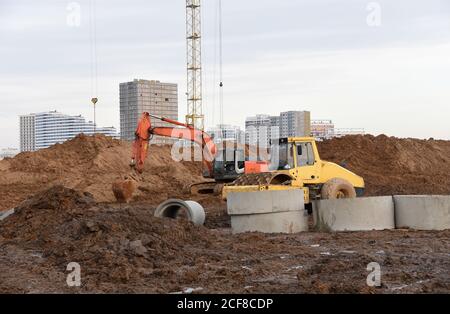 Vibration Einzylinder Straßenwalze und Bagger auf der Baustelle. Schwere Ausrüstung für Straßen- und Bodenarbeiten. Graben Fundament und Verlegung sto Stockfoto