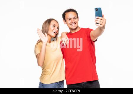 Junges Paar macht ein Selfie oder Videoanruf zusammen mit Ein Mobiltelefon mit weißem Hintergrund Stockfoto