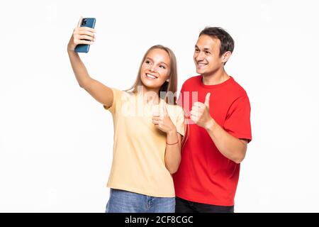 Junges Paar macht ein Selfie oder Videoanruf zusammen mit Ein Mobiltelefon mit weißem Hintergrund Stockfoto